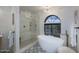 Bathroom boasts a large soaking tub, walk-in shower, and arched window at 9446 E Romping Rd, Carefree, AZ 85377