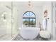 Bathroom features a large soaking tub, walk-in shower, and arched window at 9446 E Romping Rd, Carefree, AZ 85377