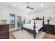 Bright bedroom with a king-size bed, wood floors, and access to a private patio at 9446 E Romping Rd, Carefree, AZ 85377