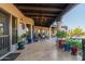 Long covered patio with comfortable seating and lush plants at 9446 E Romping Rd, Carefree, AZ 85377