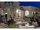 Night view of the home's entryway, showcasing a pathway and desert landscaping at 9446 E Romping Rd, Carefree, AZ 85377