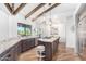 Spacious kitchen featuring granite island, dark cabinetry, and wood beam ceiling at 9446 E Romping Rd, Carefree, AZ 85377