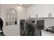 Laundry room with modern washer, dryer, and white cabinets at 9446 E Romping Rd, Carefree, AZ 85377
