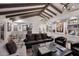 Spacious living room with hardwood floors, exposed beams, and a view to kitchen at 9446 E Romping Rd, Carefree, AZ 85377
