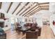 Spacious living area with hardwood floors, exposed beams, and a fireplace at 9446 E Romping Rd, Carefree, AZ 85377