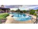 Freeform pool with a large patio and lush landscaping at 9446 E Romping Rd, Carefree, AZ 85377
