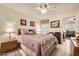 Bright bedroom features a full-size bed, ceiling fan, and a view of the living room at 145 N 74Th St # 108, Mesa, AZ 85207