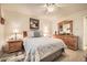 Comfortable bedroom with ceiling fan, wood dresser and nightstands, and tiled floors at 145 N 74Th St # 108, Mesa, AZ 85207