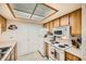 Bright kitchen features wood cabinets, white appliances, and a tiled floor at 145 N 74Th St # 108, Mesa, AZ 85207