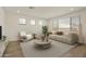 Living room with beige sofa and a large window at 17332 W Corrine Dr, Surprise, AZ 85388