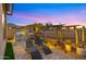 Evening view of a patio with built-in grill and lounge chairs at 23442 N 125Th Pl, Scottsdale, AZ 85255