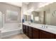Primary bathroom with double sinks, soaking tub, and walk-in shower at 2456 E Lindrick Dr, Gilbert, AZ 85298