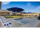 Relaxing pool area featuring blue umbrellas, lounge chairs, and a playful water feature at 30807 N 117Th Dr, Peoria, AZ 85383