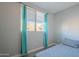 Small bedroom with a bed, and teal curtains at 3339 E Tonopah Dr, Phoenix, AZ 85050