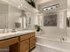Spa-like bathroom with double vanity, soaking tub, and decorative accents at 9501 E Cherrywood Dr, Sun Lakes, AZ 85248