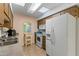 Galley kitchen with wooden cabinets, white appliances, and a sink at 13027 N 99Th Dr, Sun City, AZ 85351