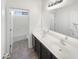 Bathroom with dual sinks, white vanity, and brown cabinets at 3317 W Hayduk Rd, Laveen, AZ 85339