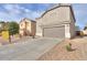 Tan two-story home with attached two-car garage, desert landscaping, and a blank for sale sign at 40092 W Hayden Dr, Maricopa, AZ 85138