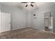 Main bedroom with ceiling fan, carpeted flooring, ensuite bathroom, and walk-in closet at 41752 W Sunland Dr, Maricopa, AZ 85138