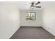 Empty bedroom with gray carpet, white walls, ceiling fan, and large window at 4481 E Sundance Ct, Gilbert, AZ 85297