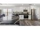 Modern kitchen with white cabinets, black countertops, stainless steel appliances, and a large island at 617 S Colonial Ct, Gilbert, AZ 85296