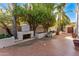 Private backyard with a fireplace, lush trees, and paved patio at 7385 E Pleasant Run, Scottsdale, AZ 85258