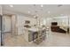 Open-concept kitchen and living area with an island, white cabinets, and wood-look tile floors at 10314 E Texas Ave, Mesa, AZ 85212