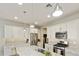 Well-lit kitchen with modern pendant lighting, white cabinets, and a granite island with sink at 10314 E Texas Ave, Mesa, AZ 85212