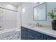Stylish bathroom with blue vanity, white subway tile, and patterned floor at 11328 E Dreyfus Ave, Scottsdale, AZ 85259