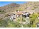 Luxury home exterior with clay tile roof and balconies nestled on a mountainside at 11328 E Dreyfus Ave, Scottsdale, AZ 85259