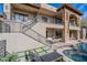 Exterior view of the home's back elevation showcasing balconies, stone accents, and a pool at 11328 E Dreyfus Ave, Scottsdale, AZ 85259