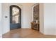 Entryway with a decorative iron door, wood floors, and a console table at 11328 E Dreyfus Ave, Scottsdale, AZ 85259