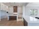 Modern kitchen with white cabinets, large island, and stainless steel appliances at 11328 E Dreyfus Ave, Scottsdale, AZ 85259