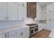 Chef's kitchen features stainless steel appliances, white cabinets, and wood accents at 11328 E Dreyfus Ave, Scottsdale, AZ 85259