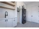 Laundry room featuring white shaker cabinets, black hardware, and a patterned tile floor at 11328 E Dreyfus Ave, Scottsdale, AZ 85259