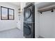 Modern laundry room with white cabinets, black appliances, and patterned tile floor at 11328 E Dreyfus Ave, Scottsdale, AZ 85259