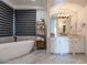 Main bathroom featuring a soaking tub, marble tile, and modern vanity at 11328 E Dreyfus Ave, Scottsdale, AZ 85259