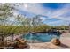 Inviting pool with a spa, surrounded by desert landscaping and a stone patio at 11328 E Dreyfus Ave, Scottsdale, AZ 85259