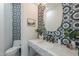 Powder room featuring patterned tile, vanity, and a decorative mirror at 11328 E Dreyfus Ave, Scottsdale, AZ 85259