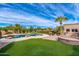 Expansive backyard oasis with a pool, artificial turf, and fire pit at 12550 E Silver Spur St, Scottsdale, AZ 85259