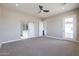 Bedroom with carpeted floors, ceiling fan, and a sliding barn door at 28211 N 213Th Dr, Wittmann, AZ 85361