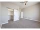 Spacious bedroom with carpet, ceiling fan, and open closet with barn door at 28211 N 213Th Dr, Wittmann, AZ 85361