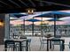 Community pool area with tables, chairs, and umbrellas at sunset at 3390 E Audrey Dr, San Tan Valley, AZ 85143