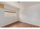 Simple bedroom with wood-look floors, window, and white walls at 3622 W Sunland Ave, Phoenix, AZ 85041