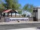 Rancho Mirage community entrance with signage, landscaping, and covered area at 36957 W Prado St, Maricopa, AZ 85138