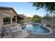 Tranquil backyard oasis with pool, waterfall, lounge chairs, and desert landscaping at 3847 N Desert Oasis Cir, Mesa, AZ 85207