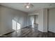 Empty bedroom featuring wood-look floors, a ceiling fan, and mirrored closet doors at 4 N 88Th Ave, Tolleson, AZ 85353