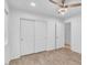 Empty bedroom with double sliding closet doors, wood-look tile floor and ceiling fan at 43558 W Harris Dr, Maricopa, AZ 85138