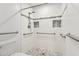 Accessible walk-in shower with white tile, grab bars, and pebble floor at 5200 S Lakeshore Dr # 204, Tempe, AZ 85283