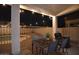 Covered patio with outdoor dining set and string lights overlooking a pool at 8775 W Lane Ave, Glendale, AZ 85305